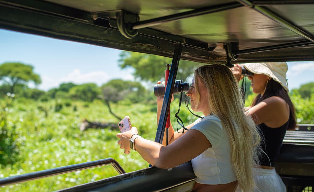 Travelers watching wildlife from inside a safari vehicle